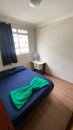 ein Schlafzimmer mit einem Bett mit einer grünen Decke darauf in der Unterkunft Apartamento completo próximo ao aeroporto CNF cidade do galo e cidade adm in Vespasiano