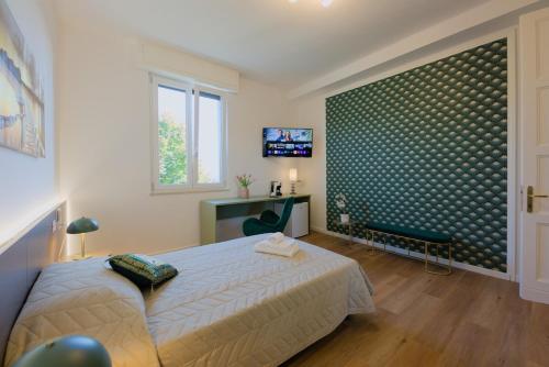 a bedroom with a bed and a desk and a television at Camera Denver - La Casa di Carta Affittacamere in Udine