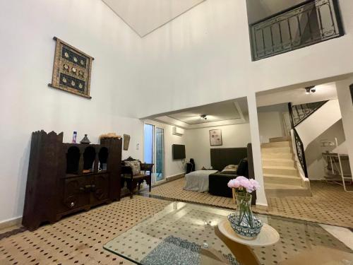 un soggiorno con un vaso di fiori su un tavolo di Au Riad Des Sultans - Marrakech a Marrakech
