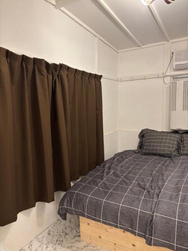 a bedroom with a bed and brown curtains at BUNKA HOUSE OSAKA room d in Osaka