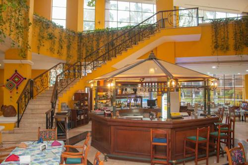 a restaurant with a bar in a building with stairs at Nk Hotel Nekié Tepic in Tepic