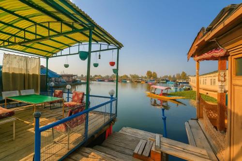 a dock with a table and chairs on the water at Lalarukh Group of Houseboats in Srinagar
