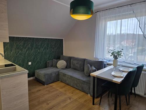 a living room with a couch and a table at Domek pod świerkami in Kudowa-Zdrój