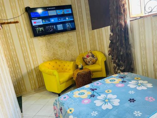 un soggiorno con sedia gialla e TV di Dar Lala Fatima Zahrae a Rabat