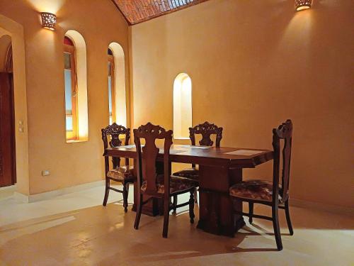 a wooden table and chairs in a room at iteru inn in Tunis