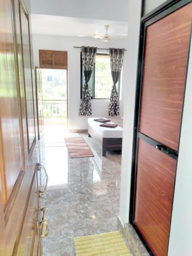 a living room with a couch and a door at MŏřĜîm ɓɛač̣ĥ řőòm in Morjim