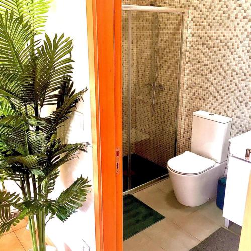 a bathroom with a toilet and a plant in it at Azurara Martins House in Azurara