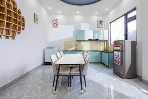 a kitchen with a table and chairs and a refrigerator at Bae Villa Đà Lạt in Da Lat