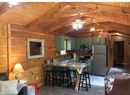 eine Küche mit grünen Schränken und einem Tisch in einer Hütte in der Unterkunft New Listing-Lil Hideaway Cabin with Peaceful Mountain Scenery! in Sevierville