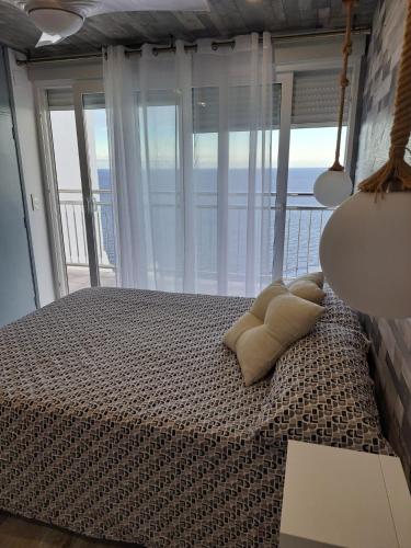 a bedroom with a bed with a view of the ocean at Blue Horizon in Almería