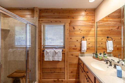 a wooden bathroom with a shower and a sink at Whiskey River by The New in Jefferson