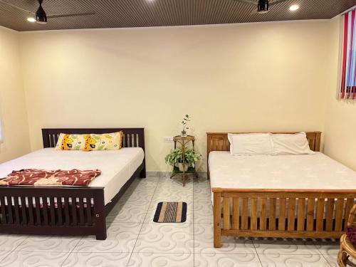 two beds in a room with two beds sidx sidx sidx at Mangattu Salkara highway view retreat in Anniyartholu
