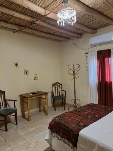 a bedroom with a bed and a table and chairs at By Lela in Tinogasta