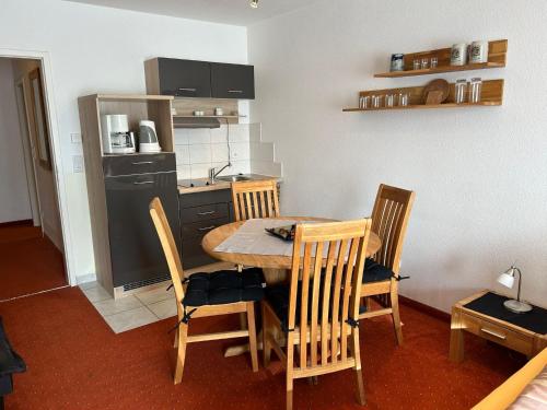 een keuken met een tafel en stoelen in een kamer bij Ferienwohnung mit Schwimmbad und Gartenblick in Sankt Englmar