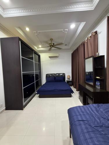 a bedroom with a blue bed and a desk at The Lodge in Kuala Kerai
