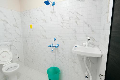 ブッダガヤにあるDev Residencyのトイレと洗面台を備えた白いバスルーム