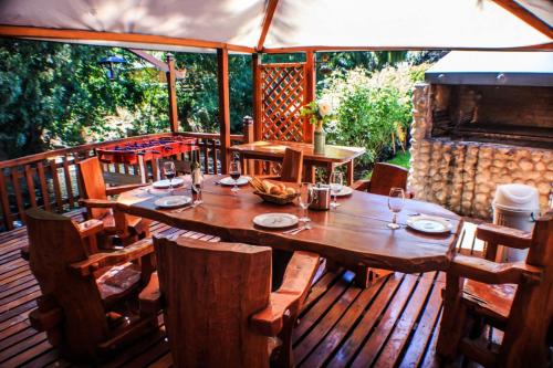 ein Holztisch und Stühle auf einer Holzterrasse in der Unterkunft Cabañas centricas Rotui Patagonia Group in San Martín de los Andes