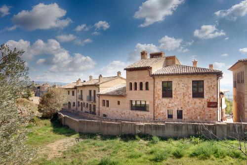 an old brick building in a field with a sky at Hotel Vinoteca Alquezar - Adults Only - in Alquézar