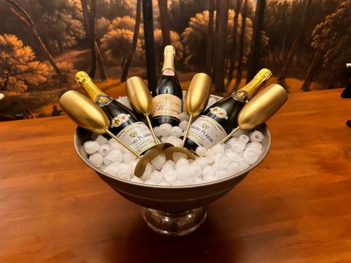 Eine mit Champagnerflaschen gefüllte Schale auf einem Tisch in der Unterkunft Wellness Tuin - Ultieme Partner Beleving - Privé Wellness Vakantiehuis met Privé Jacuzzi in Privé tuin, Privé Indoor Sauna en Privé Indoor Stoomcabine in Koloniale Stijl - Gratis Fles Prosecco & Leuke Partner Connect Box ! in Horst