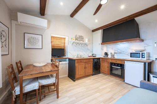a kitchen with a table and a dining room at Le Mas d'Angeline-Vue mer panoramique, jardin partagé, parking, voiture indispensable, route étroite et pentue, à 10 min de Monaco in Beausoleil