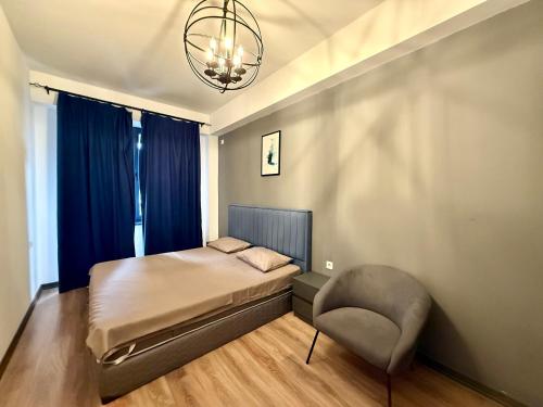 a bedroom with a bed and a chair and a chandelier at ''Malibu'' Apartment with 2 Bedrooms and Open Balcony, Yerevan CITY CENTER-Buzand Street in Yerevan