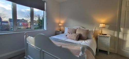 a bedroom with a bed with two lamps and a window at The Willows in Stockton-on-Tees