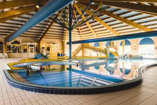 une grande piscine dans un grand bâtiment dans l'établissement Privé wellness Zen aan zee met jacuzzi barrelsauna en infraroodsauna, à Breskens