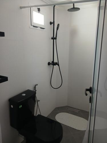 a bathroom with a black toilet and a shower at Maison almassira in Agadir