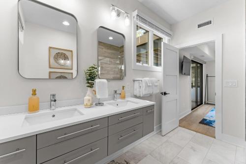 a bathroom with two sinks and a large mirror at Fox Run w/Heated Pool & Optional Boat Rental in Westport