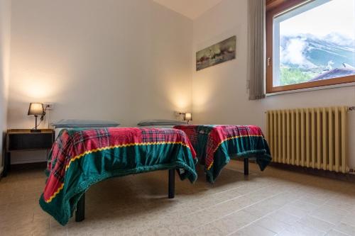 a room with two beds with blankets on them at Capole7 in Valdidentro