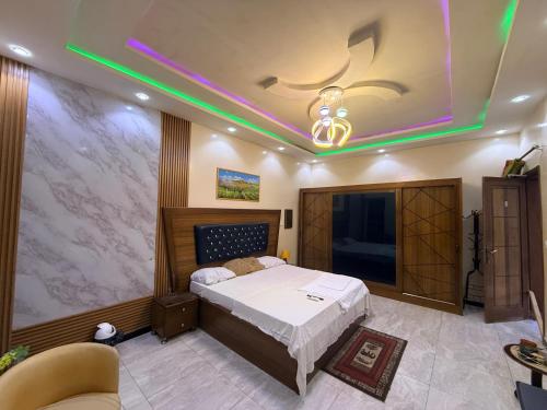 a bedroom with a bed in a room with green lights at TWO M RÉSIDENCE M&M Thies ZAC Nguinth in Thiès