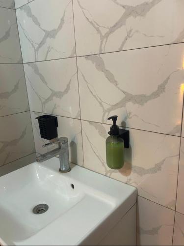 a bathroom sink with a soap dispenser on it at Oka in Déni Diarke