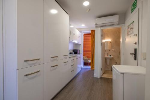 a white kitchen with white cabinets and a bathroom at Oldcity homes hotel in Istanbul