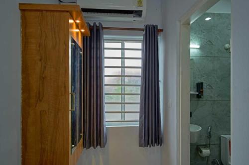 a bathroom with a window and a shower curtain at The Panakal Boho in Cochin
