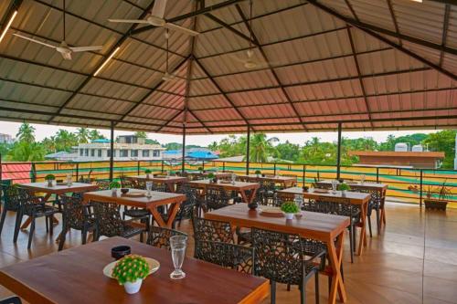 un restaurante al aire libre con mesas y sillas de madera en The Boho Stays Kochi, en Kochi