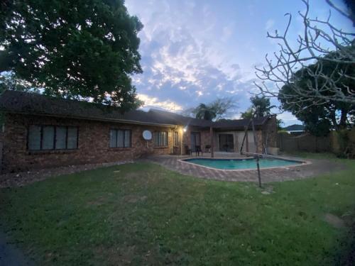a house with a swimming pool in the yard at Blissful Breeze in Richards Bay