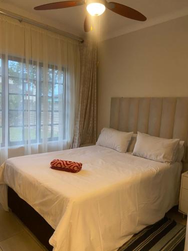 a bed with a red towel on it in a bedroom at Blissful Breeze in Richards Bay