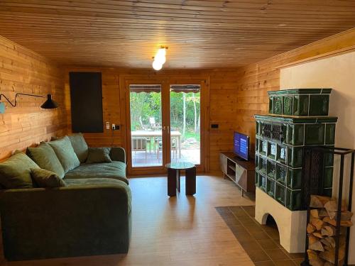 a living room with a couch and a tv at Ruhige Hütte mit toller Aussicht in Dammbach