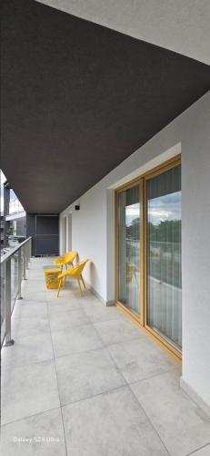 ブスコ・ズドロイにあるApartament MIRAGE NOWA DZIELNICAの建物の脇にある黄色いベンチのあるパティオ