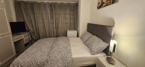 a small bedroom with a bed and a television at Heywhyjas in Manchester