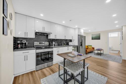 a kitchen with white cabinets and a wooden table at Brand New Private Secondary Suite in Mahogany in Calgary