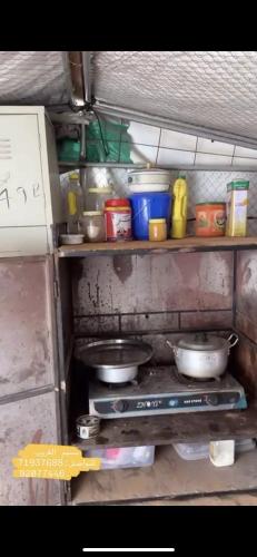 a kitchen with a stove with pots and pans at قريه الواصل in Shāhiq