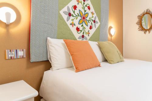 a hotel room with a bed with an orange pillow at Gran Hogar Chic I 8 min de los remontes con balcón in La Massana