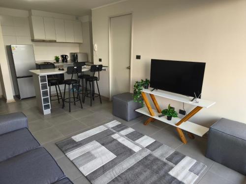 a living room with a couch and a flat screen tv at Departamento amoblado in San Pedro de la Paz