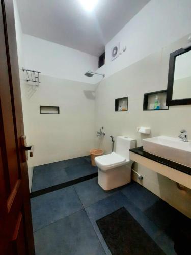 a bathroom with a toilet and a sink at Seashore Beach Resort Varkala in Varkala