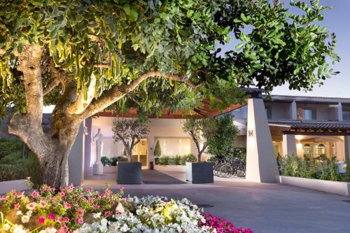 a building with flowers in front of it at Hotel San Teodoro in San Teodoro