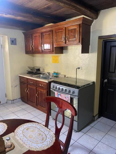 a kitchen with wooden cabinets and a stove and a chair at Casa Elia in Creel