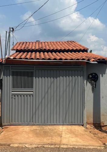 a gray building with a metal door with a red roof at Quarto privativo,não é compartilhado! in Parauapebas