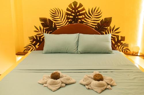 two towels are sitting on a bed in a bedroom at La Maison - Siquijor in Siquijor