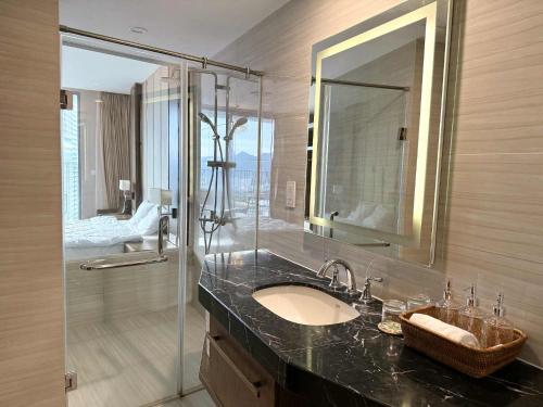 une salle de bain avec un lavabo et une douche en verre dans l'établissement Panorama Nha Trang Deluxe Double Bed City View, à Nha Trang